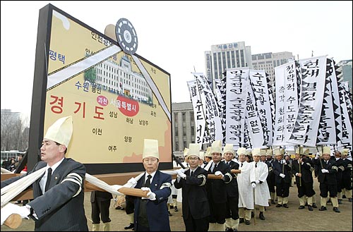 2005년 3월 15일 오후 서울시청앞 광장에서 열린 '수도분할 저지 범국민 궐기대회'에 참석한 서울시의원들이 '수도서울' 장례식 퍼포먼스를 진행하고 있다. 